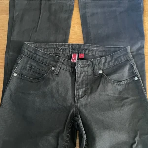 Svarta byxor från EDC, by esprit - Svarta byxor från EDC i Five-modell med raka ben och klassisk femficksdesign. Snygga detaljer med broderad logga på bakfickan och metallknapp framtill. Byxorna är tillverkade i ett mjukt bomullsmaterial med en stilren look.