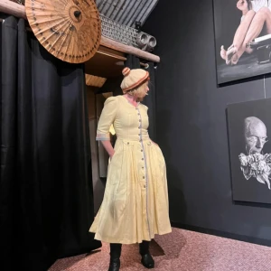 Gul vintageklänning - Ljusgul långklänning med knappar framtill från ”Butiken på Landet”. Klänningen har trekvartsärm med rutiga detaljer vid ärmslut och insida, markerad midja och vidd i kjolen. 