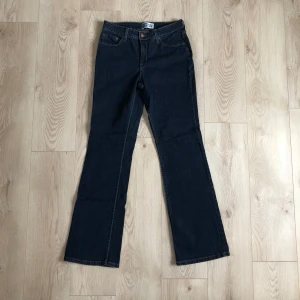 Levi's Signature Bootcut Jeans - Mörkblå jeans från Levi's Signature med klassisk bootcut-modell och midja som slutar på höften. Långa ben och bekväm passform. Tidlöst och snyggt. Nyskick!