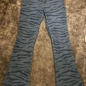 Blå zebra-mönstrade bootcut jeans - Säljer ett par blå jeans med snyggt zebramönster. Byxorna är bootcut och är hyfsat lågmidjade. Verkligen coola och unika jeans! 
