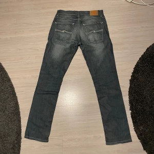 Nudie jeans Grim Tim - Säljer ett par Nudie Jeans med modellen Grim Tim. De är i storlek W34 L32 och är i bra skick. Det finns en naturlig solbleknig vilket gör byxorna väldigt unika.