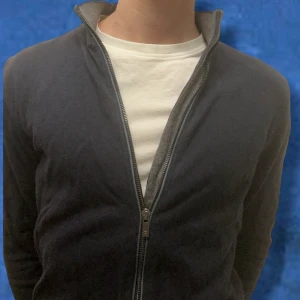 Massimo Dutti full zip - Säljer en stilren mörkblå full zip från Massimo Dutti i mycket bra skick, passar s/xs. Koftan har en dragkedja framtill och en klassisk krage. Perfekt för en elegant och avslappnad look.