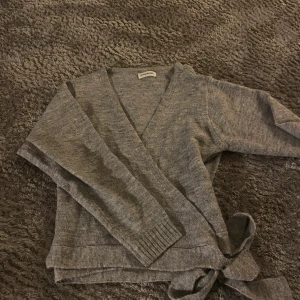 Grå omlottkofta från Even&Odd - Säljer en grå omlottkofta från Even&Odd med knyt i sidan. Koftan är aldrig använd!! 