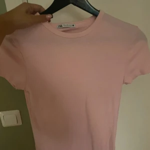 Ljusrosa t-shirt  - En basic ljusrosa t-shirt från Zara med rund halsringning, mjuk och tyget är ribbat som du ser på bilden, pris kan diskuteras!