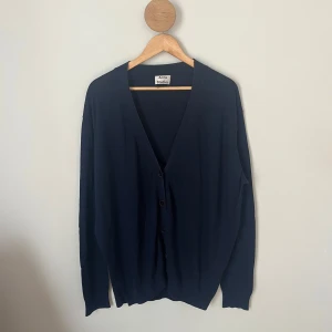 Mörkblå kofta från Acne Studios - Snygg mörkblå kofta från Acne Studios i storlek L men passar även M. Materialet är en mjuk mix av bomull och viskos som känns skönt mot huden. Är i fint skick. Hör av dig om det är något! 