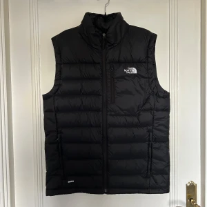 Svart dunväst från The North Face - Svart dunväst från The North Face i storlek M. Den är i nyskick, har använt den max 2 gånger. 