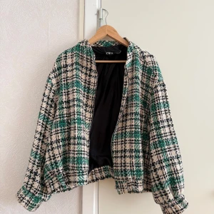 Rutig jacka från ZARA i grönt och beige - Trendig jacka från ZARA i rutigt mönster med gröna, svarta och beige toner. Jackan har dragkedja framtill, lång ärm och har en lite oversized passform på mig som annars bär strl S!