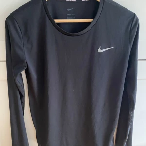 Svart långärmad träningströja Nike - Svart långärmad träningströja från Nike. Perfekt för löpning eller gympass.