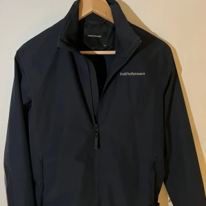 Svart vindjacka från Peak Performance - Snygg svart vindjacka från Peak Performance passar folk runt 160cm lång