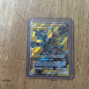 Pikachu & Zekrom GX Tag Team - Cool och glittrig Pokémon-samlarbild med Pikachu och Zekrom som tag team! Perfekt för dig som älskar Pokémon och vill ha en unik och kraftfull kort till din samling. Kortet är i skyddande plastfodral och har snygg design som sticker ut.