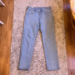 Ljusblå straight jeans från H&M - Säljer ett par ljusblå jeans från H&M med straight regular fit. Klassisk femficksmodell med dragkedja och knapp i midjan. Jeansen har raka ben och är tillverkade i mjukt denimtyg som är skönt att bära hela dagen. Storlek 29/32
