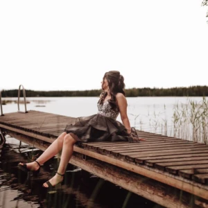 Svart paljettklänning med snörning - Säljer en kort svart klänning med glittrig paljettöverdel och v-ringning. Kjolen är volangig i flera lager av tyll och ryggen har snygg snörning. Klänningen är axelbandslös och har en riktigt festlig vibe, perfekt för bal eller student. Supersnygg och unik design!