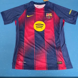 Barcelona Yamal 10  - Säljer en officiell FC Barcelona matchtröja med Yamal och nummer 10 på ryggen. Tröjan är kortärmad, har klassiska blå och röda vertikala ränder, gula detaljer och klubbmärke på bröstet. Materialet är lätt och andas, perfekt för träning eller match. Aldrig använd. Lapp finns kvar.