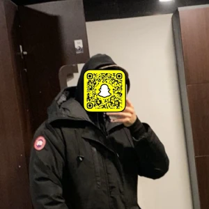 Svart dunjacka från Canada Goose - Säljer en svart dunjacka från Canada Goose med klassisk patch på ärmen. Jackan har huva, dragkedja och flera fickor. Perfekt för kalla dagar och riktigt snygg streetstil. Fodrad med dun och fjädrar för maxad värme. Kan även tänka mig byta mot Moncler Maya jacka! Jackan passar M jag ansvänder M i kläder 