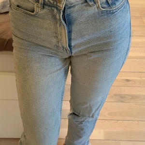 Ljusblå jeans - Säljer ett par ljusblå jeans från Pull & bear. Jeansen  har en rak passform och snygga slitningar vid knä och bakficka. Perfekt för dig som gillar en avslappnad och trendig look.