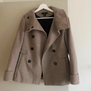 Beige kappa - Stilren beige kappa från H&M med dubbelknäppning och hög krage.