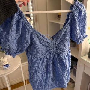 Blå topp med knyte där bak ifrån GinaTricot  - Säljer blå topp ifrån GinaTricot med knyte där bak. Använd ett fåtal gånger. 