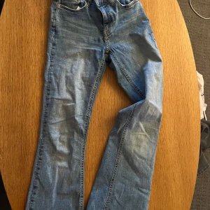 Blå jeans från Perfect Jeans, stl 32 - Säljer ett par klassiska blå jeans från Perfect Jeans i storlek 32. Jeansen har rak passform, fem fickor och snygga kontrastsömmar. Tillverkade i slitstarkt denimtyg med en tidlös look som funkar till det mesta. Perfekta för dig som gillar enkel och stilren stil.