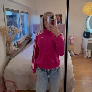 rosa adidas kofta - Superfin rosa Adidas kofta🤍 Figurnära passform med dragkedja framtill och fickor på sidorna. Bekväm och snygg 💕 Bra skick, endast en pytteliten knappt synlig svart fläck (se bild).  - Passar XS - S Skriv privat för fler bilder eller frågor 🫶🏽 