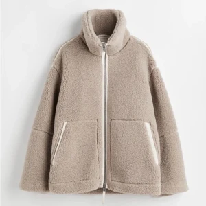 Beige teddyjacka/pilejacka  - Supermjuk och oversized teddyjacka i beige med hög krage och stora fickor framtill. Jackan har hel dragkedja och är perfekt för kalla dagar. Snygg och enkel att styla till det mesta. Finns ej att köpa på hemsidan!!