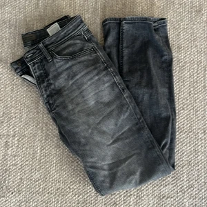 Svarta jeans med tvättad look - Hej! Säljer nu mina mörkgråa jeans från jack and Jones. Jeansen är i väldigt bra skick och väldigt bekväma. De är regular i modellen (raka/lite Slim).  Storlek: 31 W 34 L  Hör av er vid frågor!