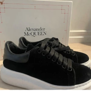 Alexander McQueen svarta sneakers - Säljer ett par ikoniska svarta Alexander McQueen sneakers med chunky vit sula. Skorna har ovandel i mocka och detaljer i skinn, samt breda svarta skosnören. Några skavanker men inget som man märker! 