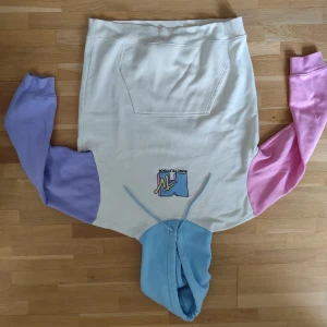 MTV hoodie i pastellfärger - Säljer en hoodie från MTV med vit kropp, lila och rosa ärmar samt ljusblå huva. Stor MTV-logga framtill i retrostil. Tröjan har känguruficka och dragsko i huvan. Perfekt för dig som gillar färg och streetwear vibes.