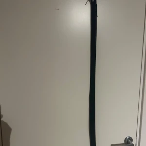 Svart skärp från Jack & Jones - Snyggt svart bälte från Jack & Jones i klassisk design. Bältet är smalt och tillverkat i äkta skinn, perfekt för att ge en clean look till dina jeans eller chinos. Diskret logga präglad på insidan för extra stilpoäng.