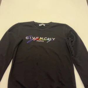 Svart Givenchy sweatshirt med brodyr - Svart sweatshirt från Givenchy med färgglad broderad logga på bröstet. Tröjan är i ett perfekt  skick och är ej använd så många gånger. Den är äkta och är perfekt för en fest eller bara en kväll med vännerna. Materialet känns mjukt och skönt, perfekt för en chill och stilren look. Storleken är L men passar folk som har storleken M också. Pris kan diskuteras.