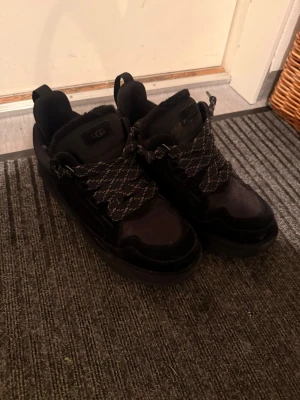 Ugg lowmel - Använda ca 3 gånger box o kvitto finns storlek 45. Svarta sneakers från UGG med tjocka, mönstrade snören och mjuk, fluffig insida. Skorna har rund tå, platt sula och detaljer i mocka och syntet. Perfekta för dig som gillar en sportig och bekväm stil. 