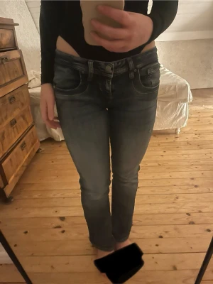 Lågmidjade blå jeans bootcut från LTB - LTB jeans. Säljer ett par lågmidjade blå jeans med bootcut passform. Jeansen har klassiska fem fickor och kontrastsömmar. Perfekta för dig som gillar en avslappnad men ändå trendig look. W27 L30 