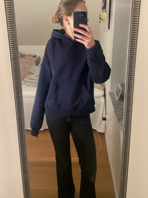 Mörkblå hoodie från Gina tricot - Snygg mörkblå hoodie från Gina i storlek XS. Klassisk modell med huva och stor magficka framtill. Perfekt för en avslappnad och stilren look. Mjuk och skön bomullsblandning som passar till det mesta.