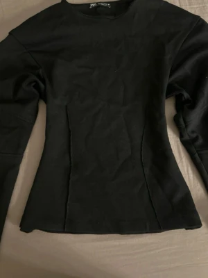 Svart långärmad topp från Zara - Snygg svart långärmad topp från Zara med figurnära passform och rund halsringning. Tillverkad i mjukt bomullsmaterial som känns skönt mot huden. Enkel och stilren design som passar till många olika looks. Säljer därav att den inte kommer till användning längre. Skriv för fler bilder 💋