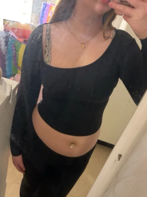 Svart ribbad croppad topp - Säljer en svart, ribbad och croppad topp med lång ärm.