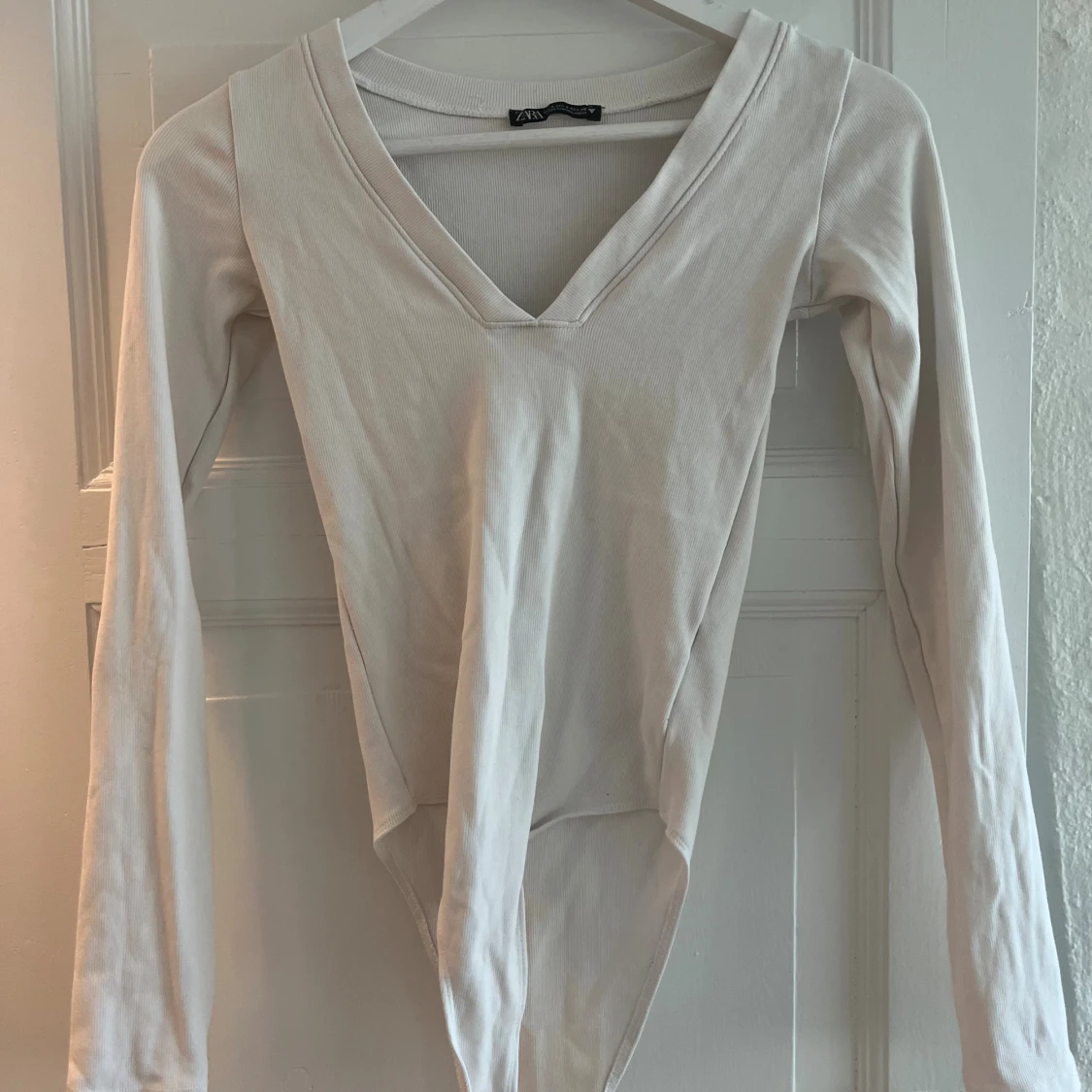 Vit långärmad body med V-ringning