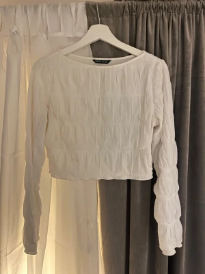 Vit långärmad topp🥰 - Jättefin och söt vit topp från SHEIN, som är långärmad. Toppen har en ribbad struktur och är tillverkad i ett mjukt material som ger en snygg och bekväm passform. Passar till alla tillfällen och är jätte fin till ett par jeans eller kjol🙌🏻🙌🏻