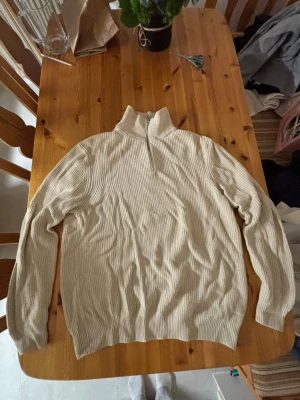 Beige ribbad stickad tröja från Zara - Säljer en beige ribbad stickad tröja från Zara med hög krage och half zip-dragkedja. Tröjan har lång ärm och är i mjukt material som passar perfekt till lager på lager. Enkel och clean look som funkar till allt.