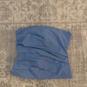 Blåvit randig bandeau tubtopp - Snygg blå tubtopp med vita ränder från Zara. Toppen är axelbandslös och har ett draperat tyg som ger en cool och modern look. Perfekt att matcha med jeans eller kjol för en trendig outfit.