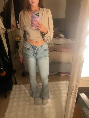 Ljusblå bootcut jeans Mid waist - Snygga ljusblå jeans med bootcut-modell och är mid waist. Jeansen har storleken xs/34, har även klassisk femficksdesign och är tillverkade i ett mjukt denimtyg som sitter bekvämt. 