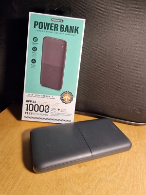Power Bank 10000mAh - Remax RPP-23 Power Bank med 10000mAh kapacitet, stöd för snabbladdning (2.4A), USB och Type-C portar. Kompakt och stilren design, batteriindikatorer, passar perfekt för laddning av mobila enheter. Enheten är I ny skick och endast använd i en vecka. 