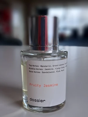 Dossier Fruity Jasmine Parfym - Fruity Jasmine från Dossier. Toppnoter: mandarin, gröna blad, mellan: jasmin, ylang ylang, bas: sandelträ, plommon, mysk. En modern doft med fruktiga och blommiga inslag – perfekt för dig som vill sticka ut. Se bilder för mängd kvar. 
