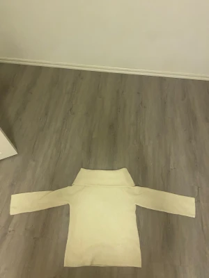 Beige polotröja från H&M, stickad - Mysig beige polotröja från H&M i stickat material. Tröjan har lång ärm, bred polokrage och en rak passform. Perfekt för lager-på-lager och chill höst- eller vinterstil.