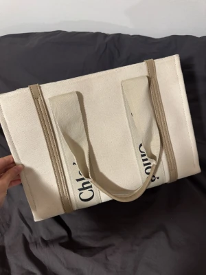 Beige tote bage - Beige strukturad tote bag från Spanien. Står nog för en dator