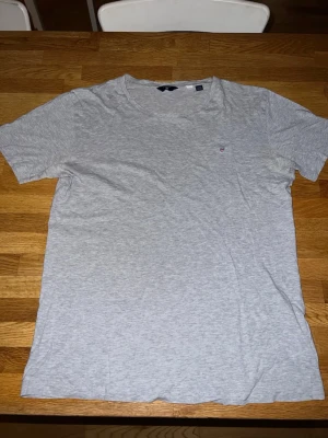 Gant T-shirt - Skön T-shirt från gant i färgen grå. Storlek 170 cm/15 år. Okej skick, har ett hål där fram(fjärde bilden). 