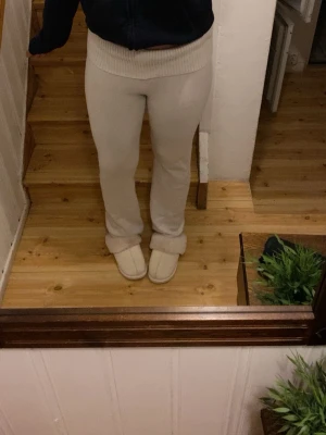 Vita mjukisbyxor med ribbad midja - Säljer ett par vita mjukisbyxor med bred ribbad midja. Byxorna har en rak passform och är gjorda i ett mjukt material som är perfekt för chill dagar hemma. Färgen är ljus  och de sitter skönt över höfterna.