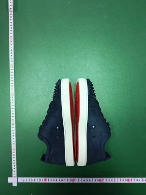 Mörkblå mocka sneakers Christian Louboutin - Säljer ett par mörkblå sneakers från Christian Louboutin i mjuk mocka. Skorna har vita sulor med den klassiska röda undersidan och coola svarta nitar på tån. Insidan är beige och de har snörning framtill. Perfekt för dig som vill sticka ut med exklusiv streetstyle.