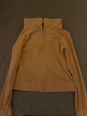 Juicy kofta  - Aprikos/korall färgad kofta ifrån Juicy Couture jätte fint skick, inga fel . Strl L, liten i storleken så passar nog M också.