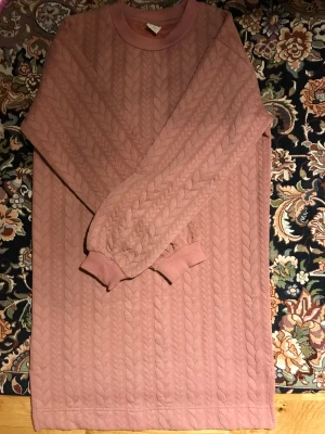 Rosa långärmad tröja från Lindex - Säljer en rosa långärmad tröja från Lindex med snyggt quiltat flätmönster. Tröjan har ribbade muddar vid hals och ärmslut, och är gjord i mjuk bomull. Perfekt för dig som gillar en chill och stilren look.