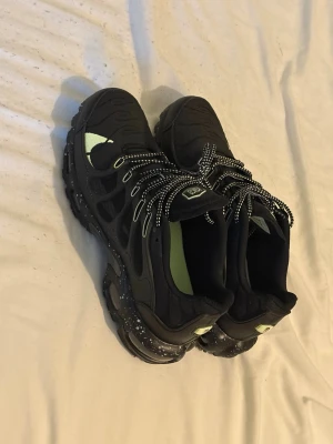 Nike Air Max svarta sneakers strl 43 - Nike Air Max sneakers i svart med detaljer i ljusgrönt och vita prickar på snörningen och sulan. Snygg mesh och syntet på ovandelen, robust platt sula med stänk av färg och synliga Air Max-enheter. Skorna har rund tå och coola snörningsdetaljer.