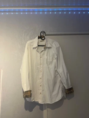 Burberry skjorta - Burberry skjorta, aldrig använd i mitt ägo. Storlek L                                                              Fint skick (endast en extremt liten fläck, se sista bilden)